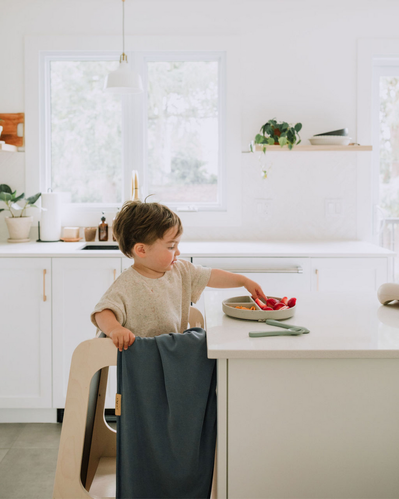 Enfant qui mange avec vaisselle en silicone couleur pistache.