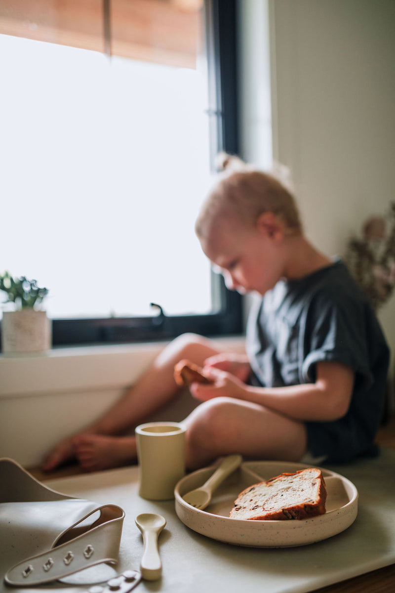 Enfants qui mange avec vaisselle en silicone couleur maïs.