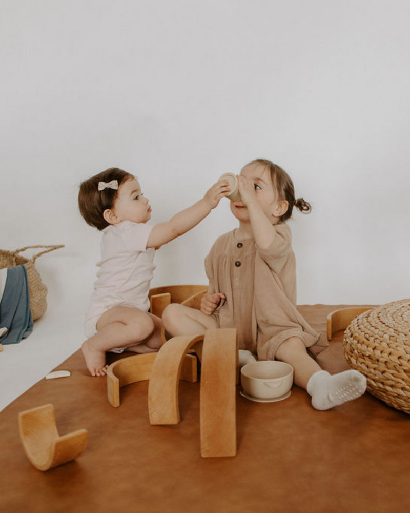 Enfants qui jouent sur tapis de cuir végétalien couleur tan.